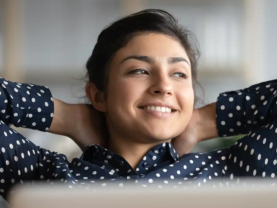 Satisfied woman leaning back with her hands behind head